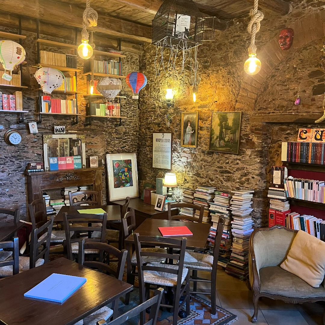 La sala della Piccola Biblioteca di Cuti, con muri di pietra, libri, lanterne e mongolfiere di carta